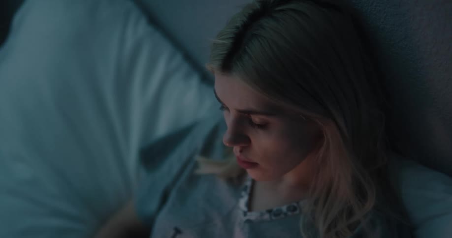 A woman lays in bed with her cell phone