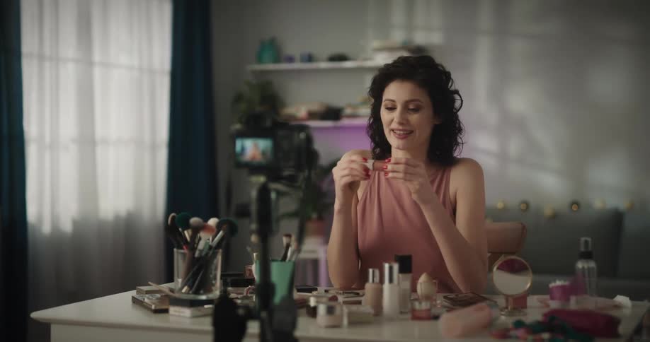 A woman films herself looking at makeup and talking