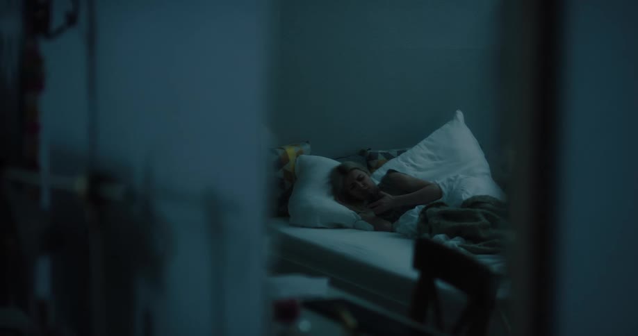 A woman checks her smartphone while trying to go to sleep