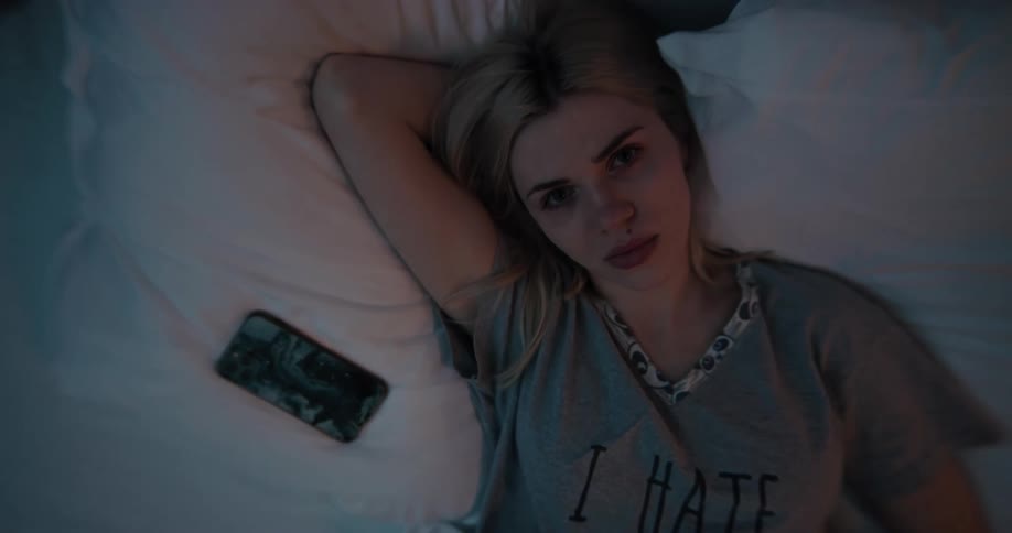 A woman is laying down in bed at night