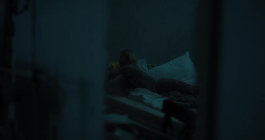 Young white woman lying in her bed leafing through a magazine and then turning off the table lamp and going to sleep