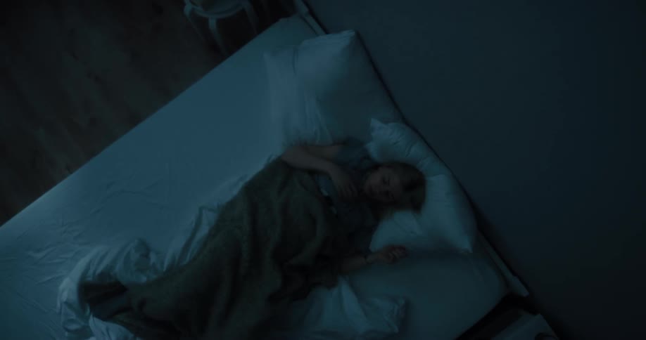 Blonde woman sleeps in bed at night in the bedroom