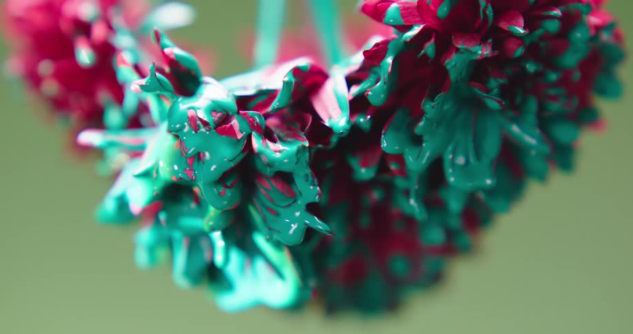Green paint is dripping from a red carnation flower