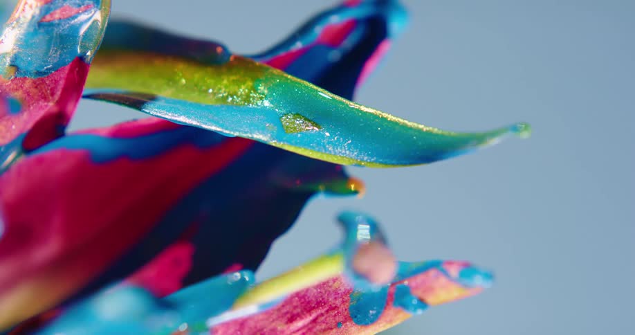 Wind ripples water coating unpainted and painted portions of a flower