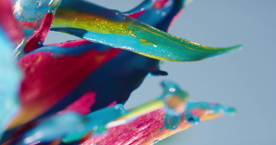 Blue paint drips from a plant leaf