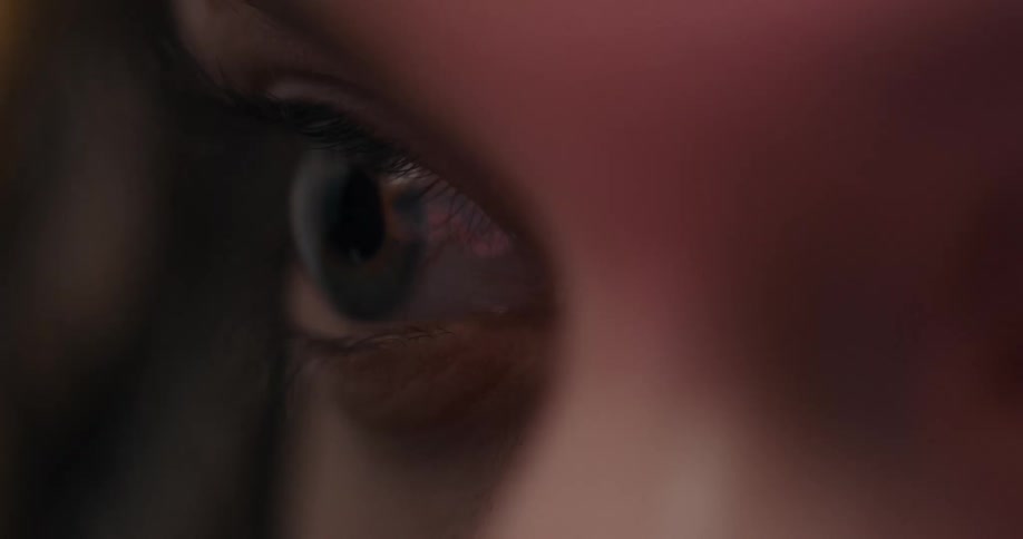 A woman tries not to blink as a light flashes past her eyes