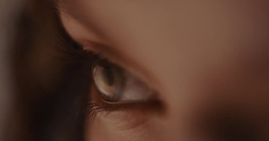 A woman doesnt blink as a video shes watching flashes on her eye