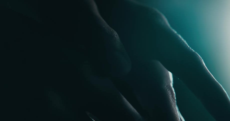 A person is holding their hands together at night