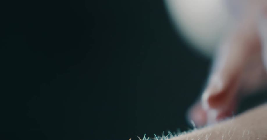 Person strokes hands over the fine hairs on their arm