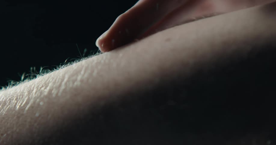 A woman caresses a mans arm