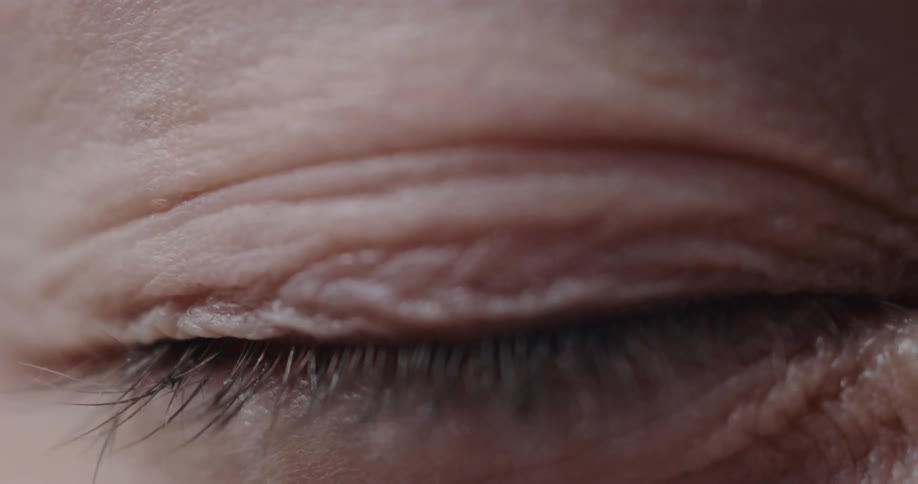 Closeup view of a person closing their eyes is displayed