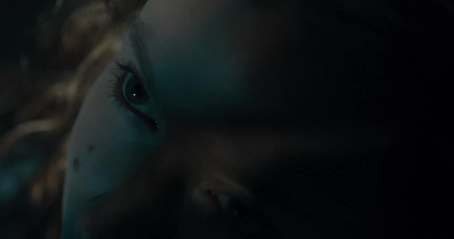 A woman looks up from the dark