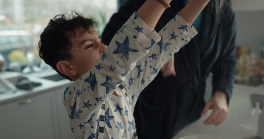 A man and his young son shake as they cook together at home