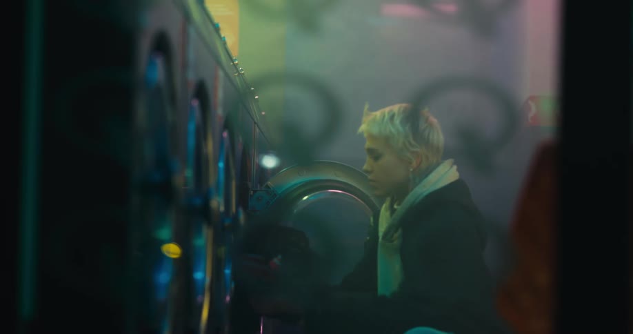 A woman removes her clothes from the washing machine