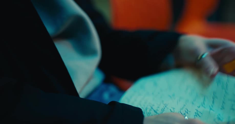 A woman tears a page out of her notebook