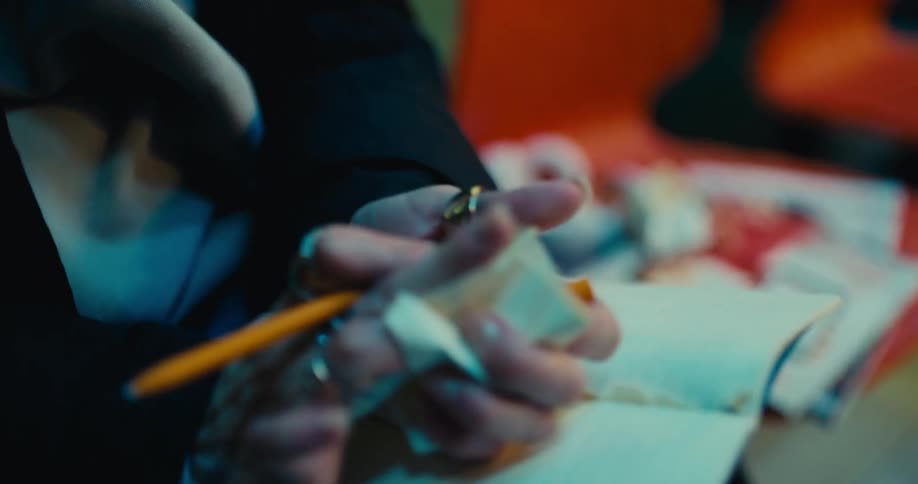 A woman rips out a piece of paper and tosses it in frustration