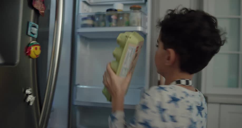 A father and son pull ingredients out of the fridge