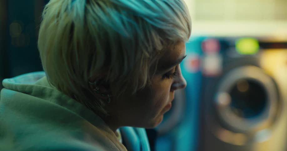 A woman sits down in the laundromat
