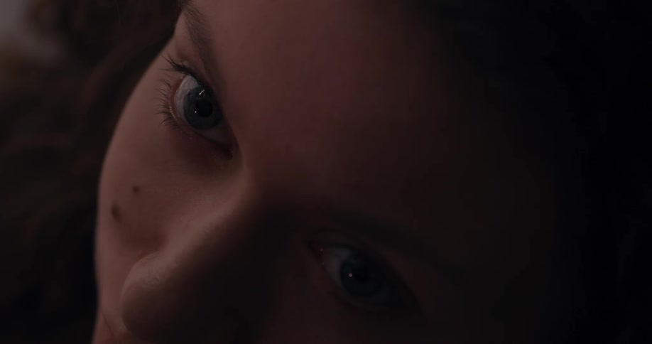 Light and shadow flows across still womans face causing her pupils to grow and shrink