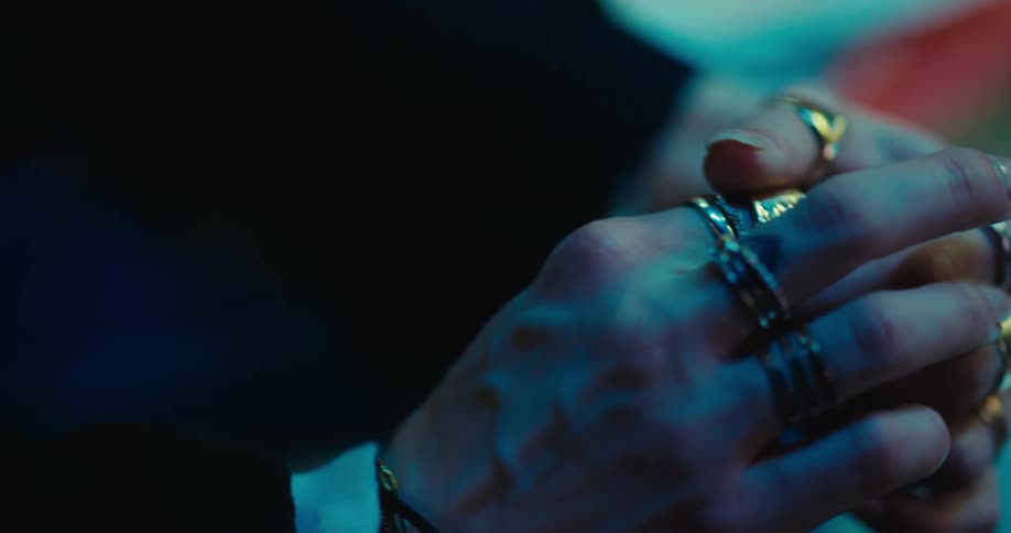 A woman turns the rings on her fingers
