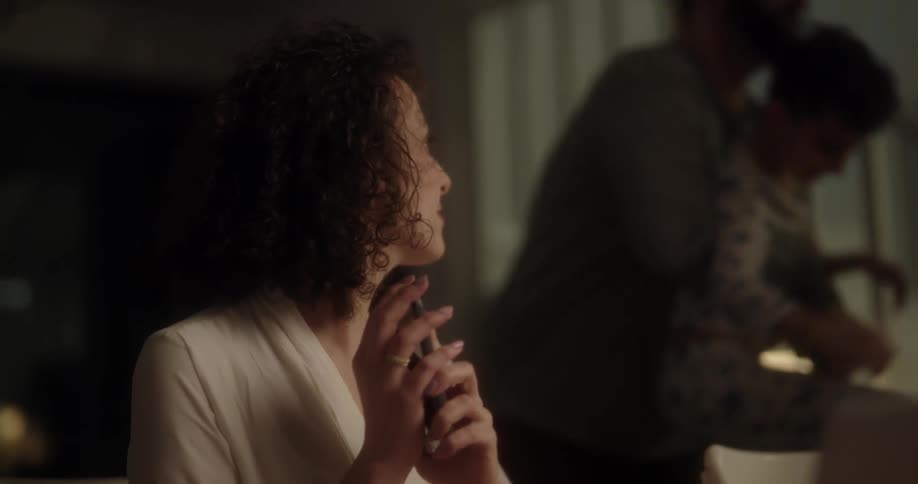 Woman talking on the phone when her son approaches bothering her and the father comes and takes him away