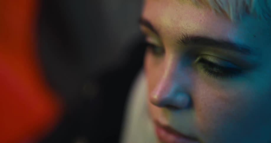 A woman looking up and around then tapping her phone screen with her thumbs
