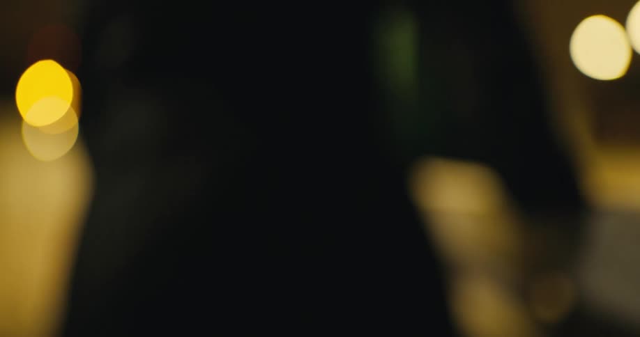 Crying woman stands and walks away toward nearby city lights