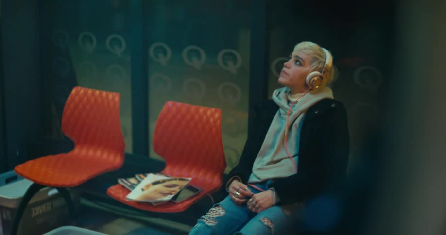A woman is sitting in a chair and listening to music