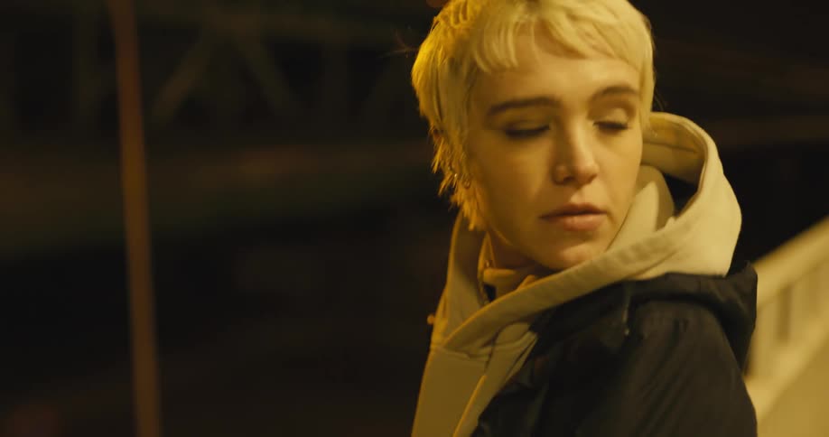 A woman walks to the road at night