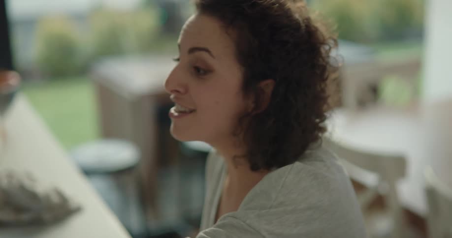 White woman eating food at a kitchen counter and enjoying it a lot