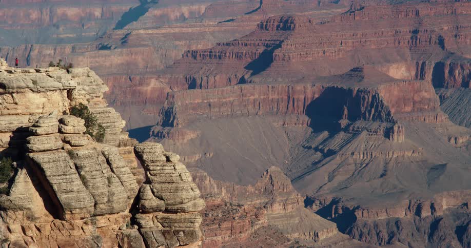 The sun shines brightly on rock formations and mountains