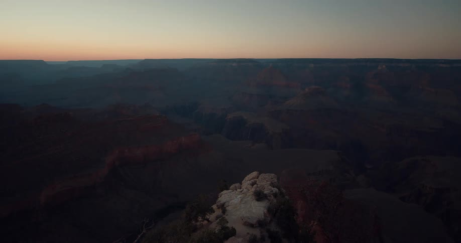 A series of vast canyons under a clear sky at sunset