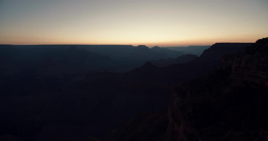 The sun is setting in the horizon of a landscape