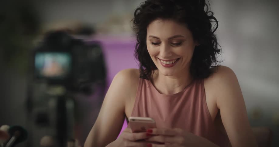 A woman laughing while texting on her cell phone