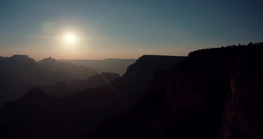 The sun is setting in the horizon of a landscape