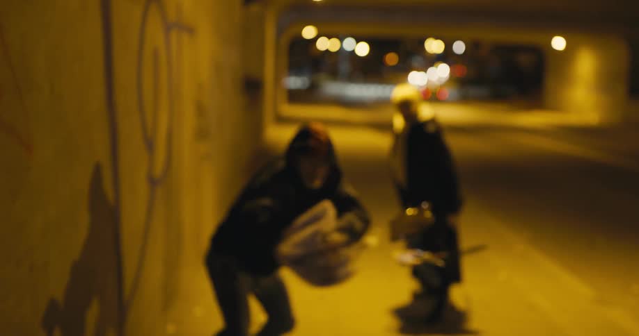 White woman walking down a tunnel at night when a man wearing a hoodie approaches and steals her purse and she screams back in anger
