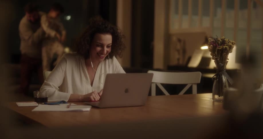 Woman trying to work at home while her husband and son play on the background