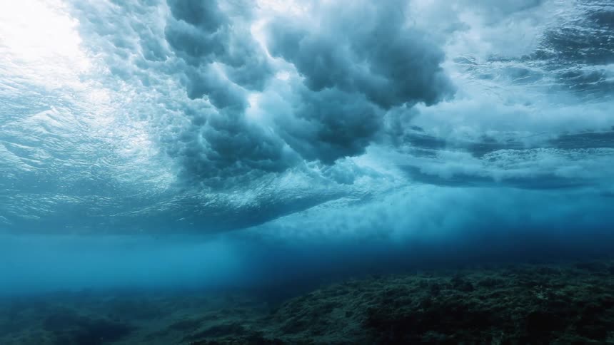 A wave crashes giving clouds underwater
