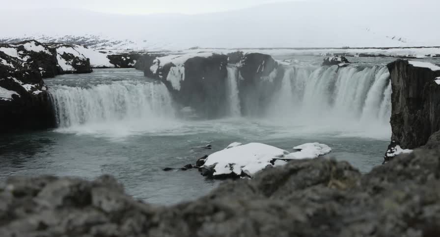 Two waterfalls leading to a body of water