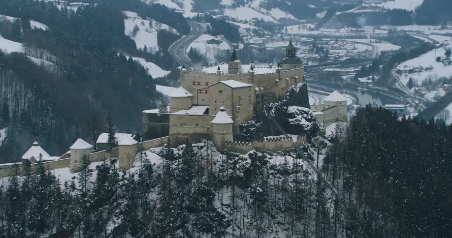 Aerial view of a castle over a mountain near a small town at winter