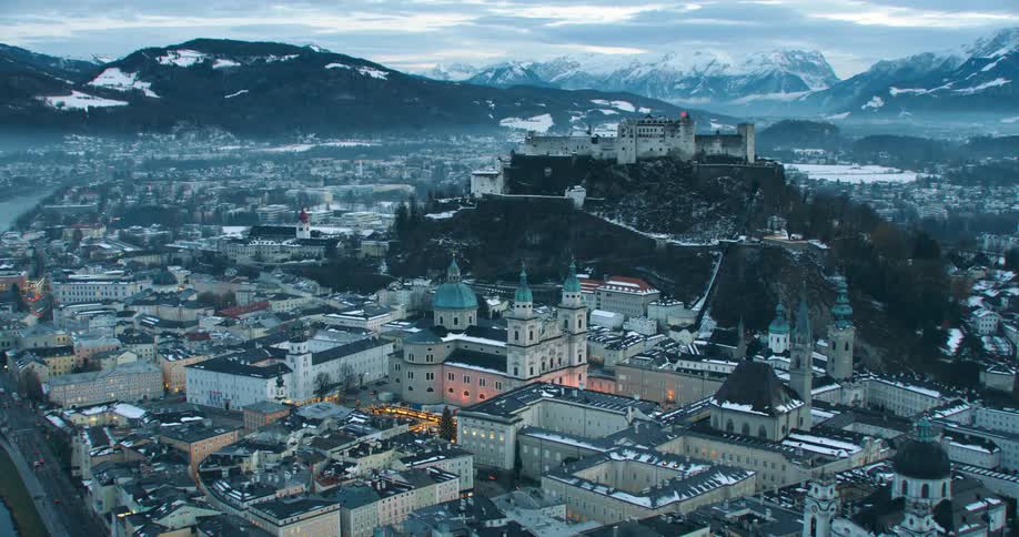 Aerial view of a river flowing through a city covred in fog in the mountains