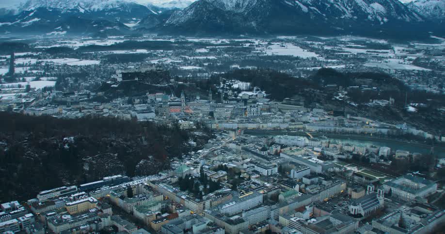 Aerial view of a small town in a valley near a snow covered mountain range