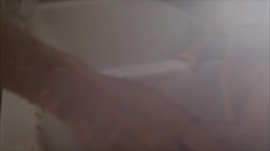 A mother washing her baby in a kitchen