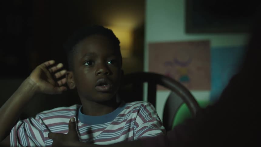 A boy sitting in a chair at a table