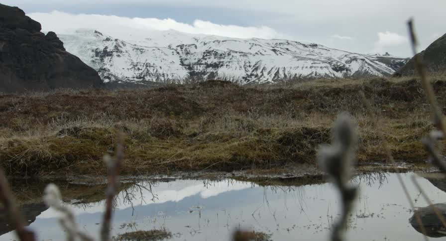 A body of water is before a snow covered mountain