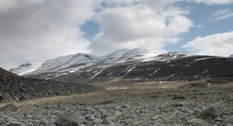 Barren area with mountains in the background on a cloudy day