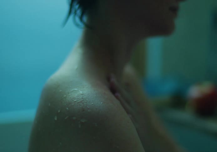 Neck and shoulders of a young woman takes a bath inside a bathtub in the bathroom