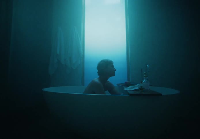 A woman sits in a bath tub and bathes