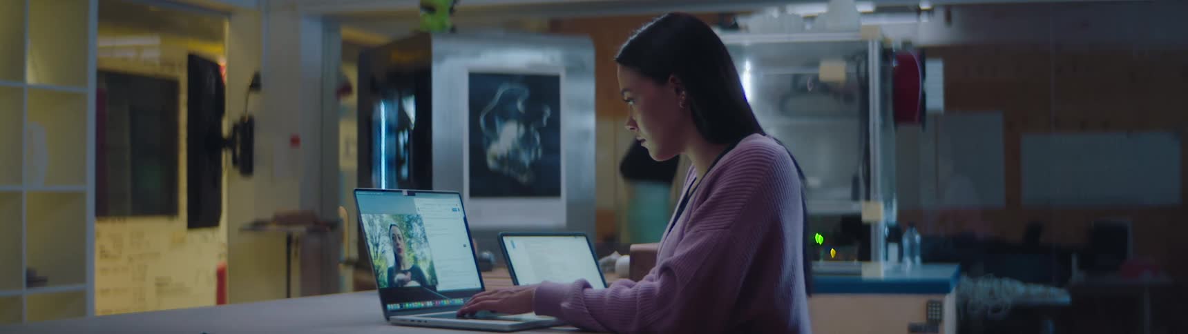 A woman sits in an office and video chats with another woman
