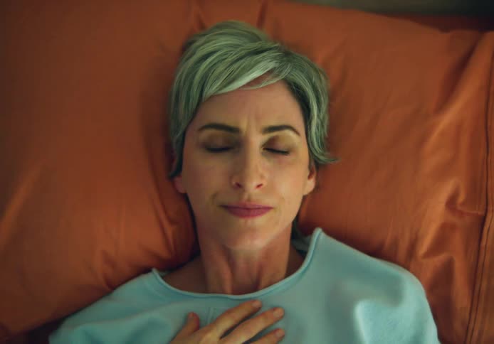 A woman rolls over to face up in bed